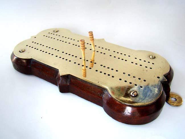 A fine Victorian brass cribbage board on a shaped oak base circa 1860